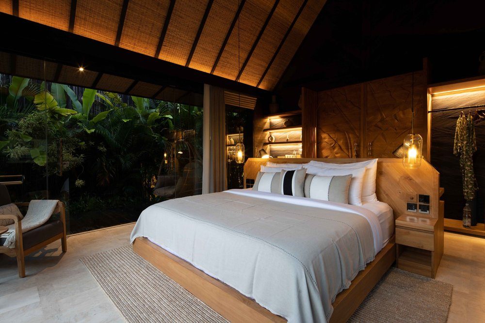Villa interior with king-size bed and floor-to-ceiling windows