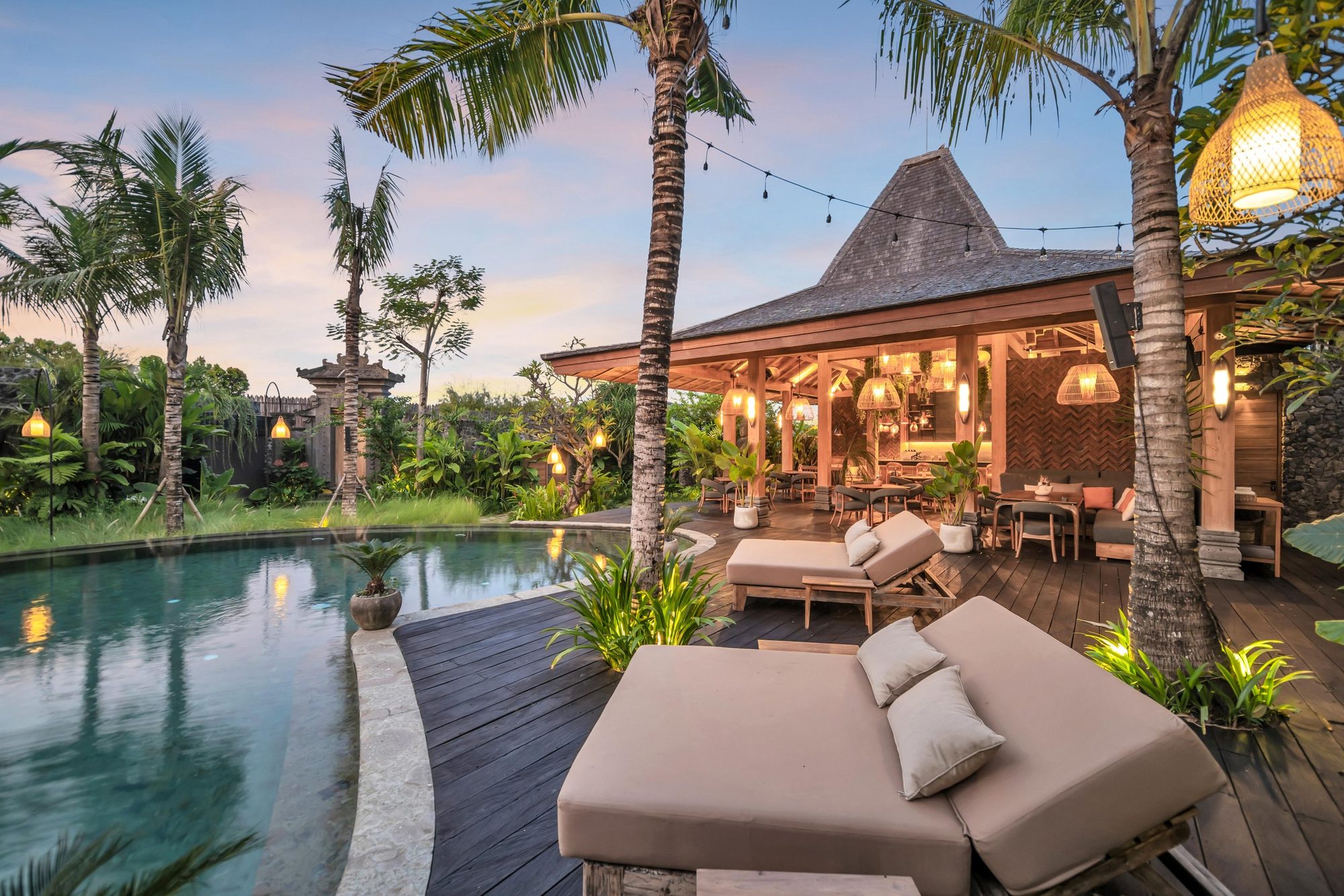 The pool, loungers and Ijo restaurant lit at dusk